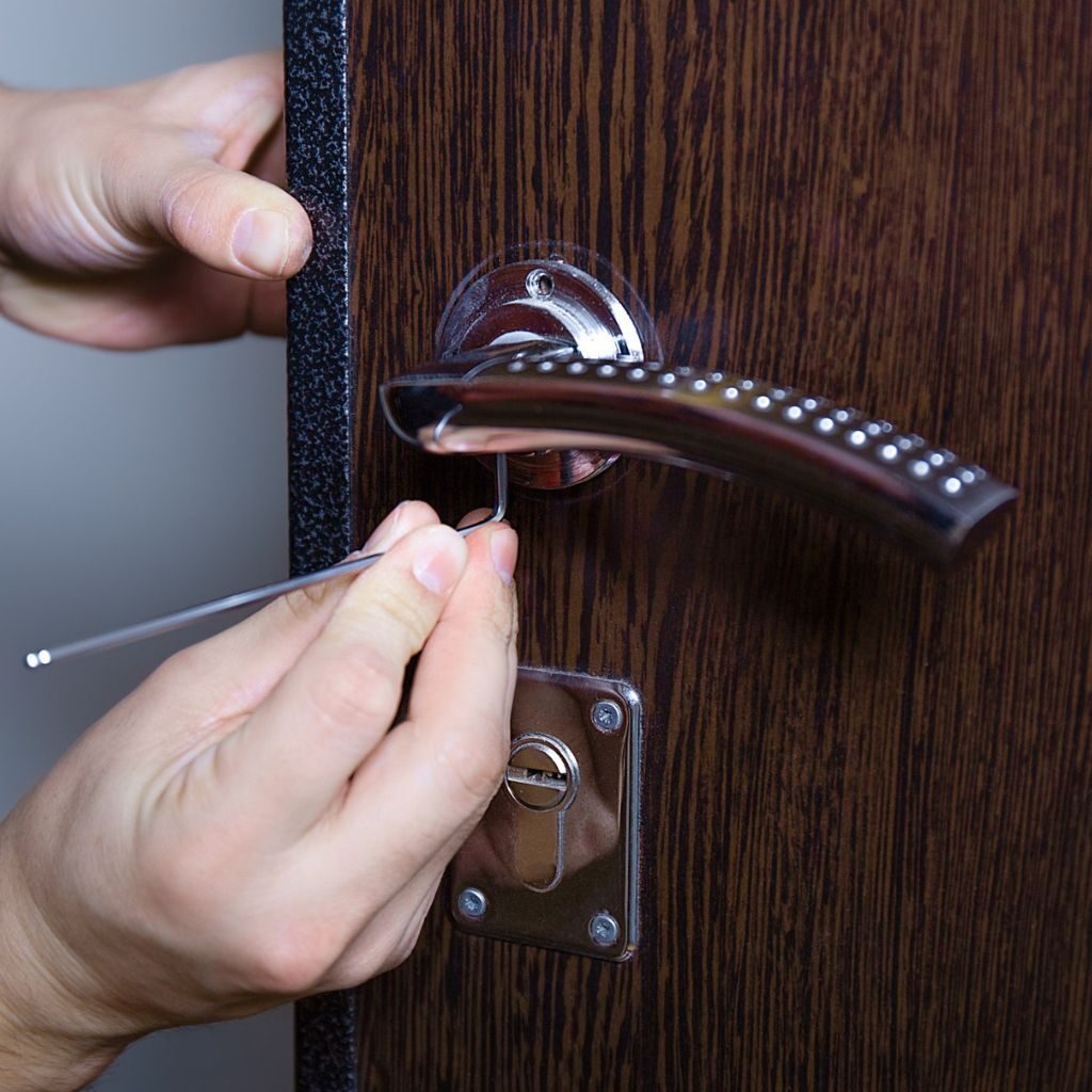Slotenmaker vervangt een deurslot in een houten deur met handgereedschap